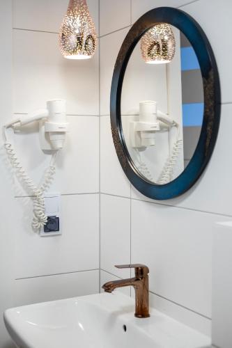 a bathroom with a sink and a mirror at 4 Pory Roku Apartamenty Domki Pokoje in Nadole
