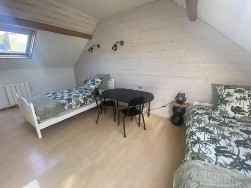 Habitación con cama, mesa y sofá en La Clé de Julian, en Amiens