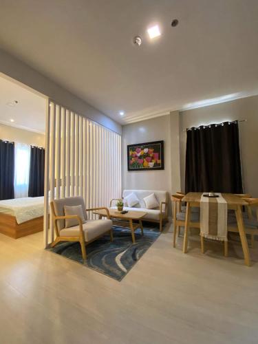 a living room with a bed and a table and chairs at Hyde Tower in Cebu City