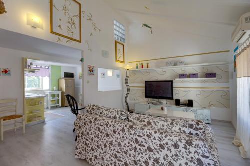 een slaapkamer met een bed en een tv aan de muur bij Apartments Mandarina in Mali Lošinj