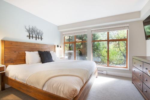 1 dormitorio con 1 cama grande y ventanas en Whistler Vacation Club at Twin Peaks en Whistler