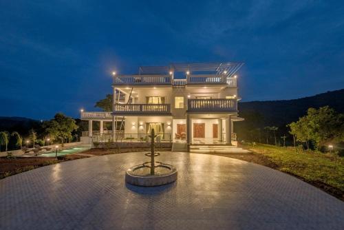 a large house with a fountain in front of it at SaffronStays Ivory Mansion in Pen