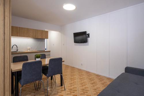 a kitchen and dining room with a table and chairs at 4 Pory Roku Apartamenty Domki Pokoje in Nadole