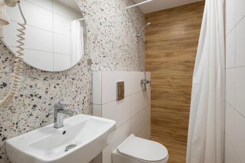 a bathroom with a sink and a toilet and a mirror at 4 Pory Roku Apartamenty Domki Pokoje in Nadole