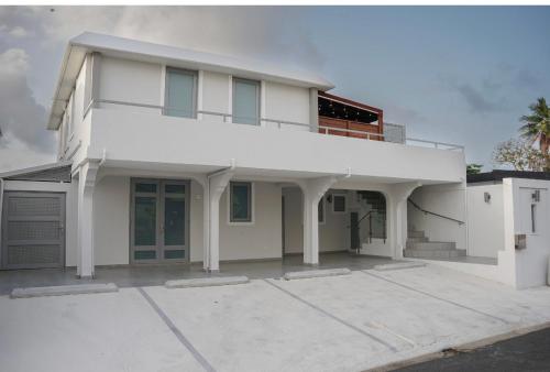 a white house with a garage at North Breeze Guest House 1 in Levittown