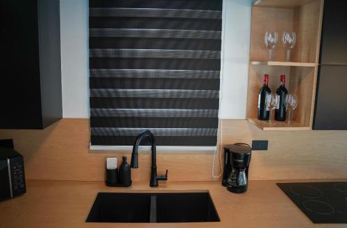a kitchen counter with a sink and wine glasses at North Breeze Guest House 1 in Levittown