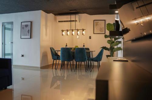 a dining room with a table and blue chairs at North Breeze Guest House in Levittown