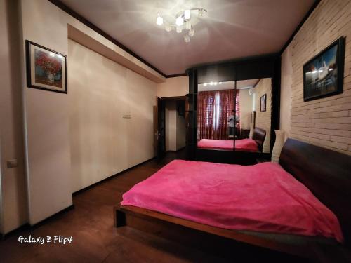 um quarto com uma cama grande e um cobertor rosa em Hatai em Baku