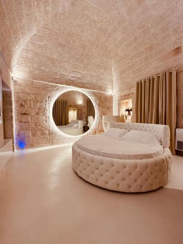 ein großes Bett in einem Zimmer mit einer Backsteinwand in der Unterkunft Secret Suite in Monopoli