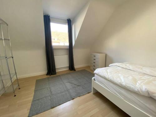 um quarto com uma cama, uma janela e um tapete em Ruhiges DG - 6 P. - urban - ÖPNV em Colônia