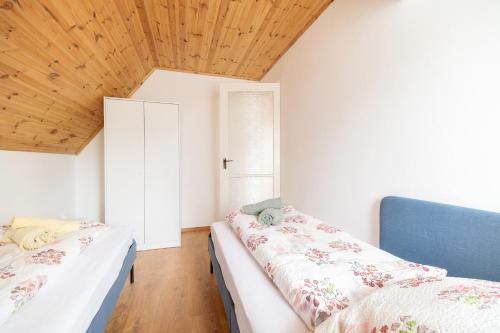 1 dormitorio con 2 camas y techo de madera en BoRóza Vendégház, en Zebegény