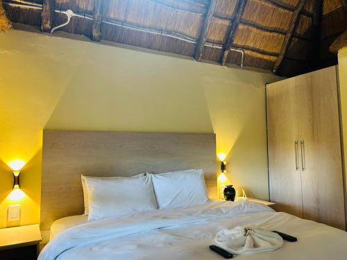 a bedroom with a large bed with two towels on it at THE GALAXY FOREST LODGE in Manguzi