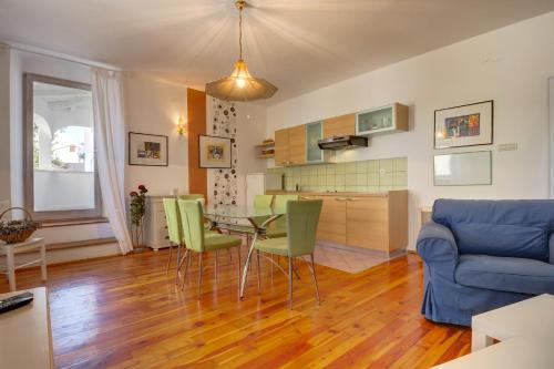 a living room with a table and green chairs at Apartments Mandarina in Mali Lošinj