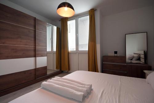 um quarto com uma cama com duas toalhas brancas em Mitovski Apartment em Skopje