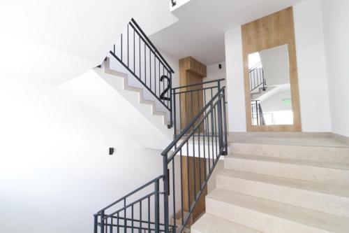 a staircase with black railings in a white house at Deea H24 in Râşnov