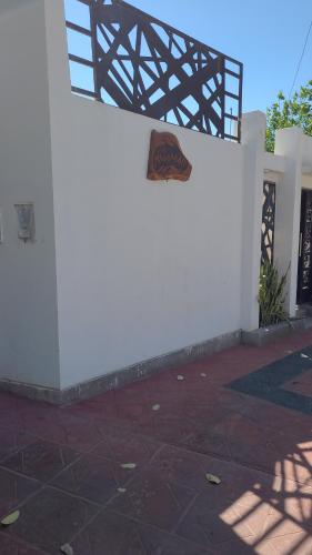 un edificio blanco con un cartel en el costado en Alborada en San Fernando del Valle de Catamarca