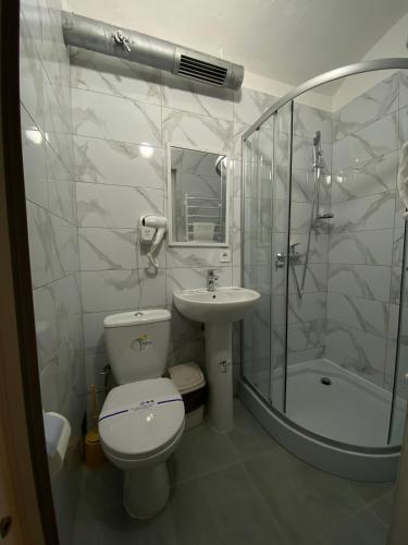 Un baño con inodoro, lavabo y ducha. en Лісапед на Зустрічній, en Leópolis