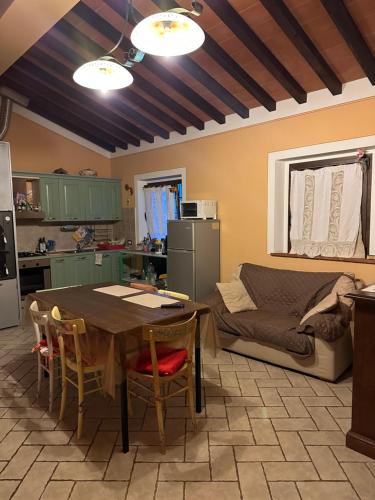 cocina y sala de estar con mesa y sofá en CASA ALBERELLO, en Torrita di Siena