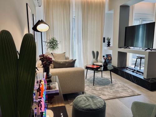 a living room with a couch and a flat screen tv at Alice, 2-4 people, renovated stylish apartment in Athens