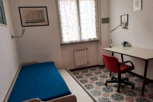 een kamer met een bed, een bureau en een stoel bij Casa Erica in Chiavari