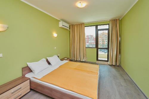 ein Schlafzimmer mit einem Bett und einem großen Fenster in der Unterkunft Evi Apartments 2 in Pomorie