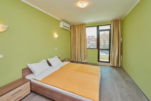 a bedroom with a bed and a large window at Evi Apartments 2 in Pomorie