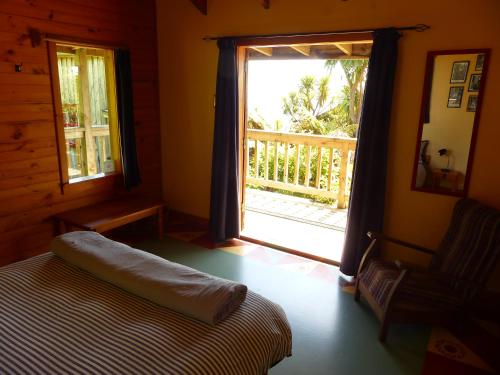 a bedroom with a bed and a window with a porch at The Old Slaughterhouse Traveller's Lodge in Hector