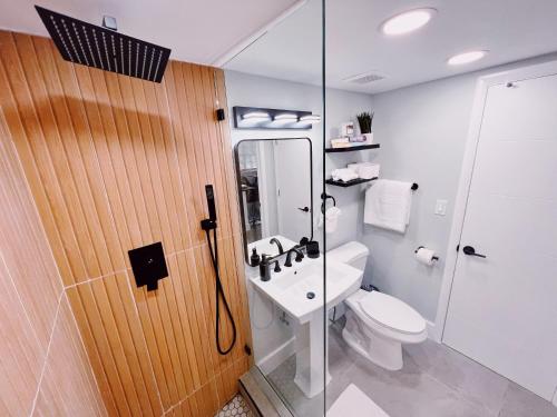 baño con ducha, aseo y puerta de cristal en Holiday Park Apartments by Lowkl, en Fort Lauderdale