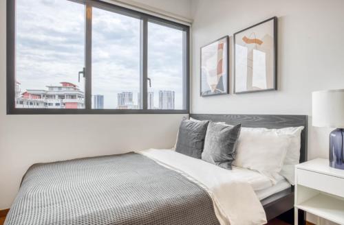 新加坡的住宿－The Elite Enclave 2Bedroom Apartment in Singapore!，一间卧室设有一张床和两个窗户。