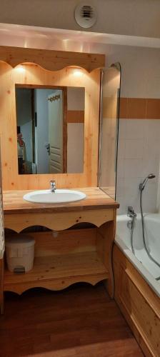 une salle de bain avec un lavabo, un miroir et une baignoire dans l'établissement Orelle Val Thorens Appartement 2 pieces 5 personnes, à Orelle