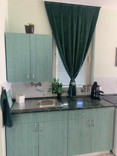 a kitchen counter with a sink and a window at Angyalszív Apartman in Zalakaros