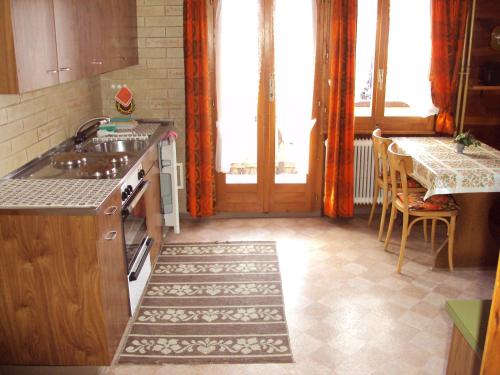 a kitchen with a sink and a table with chairs at Heiderösli 1st Floor and Attic Apartment in Grächen
