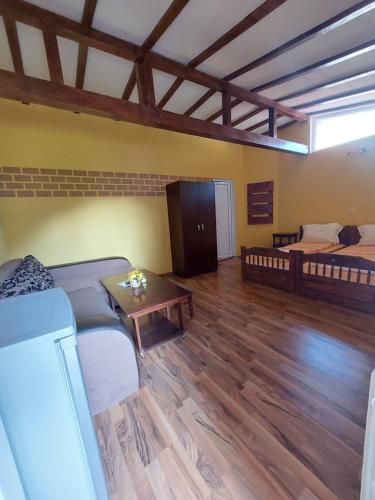 Sala de estar con 2 camas y mesa en Стаи за гости Върбите, en Sapareva Banya
