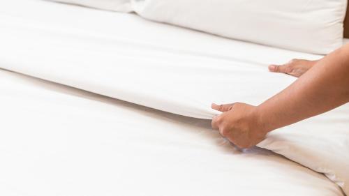 a person laying on a bed with their hand on the sheets at Georgetown Lodge in Georgetown
