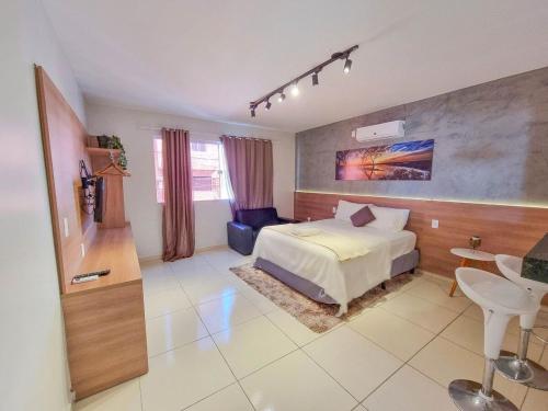 a bedroom with a bed and a table and a chair at Rize Studios in Maceió