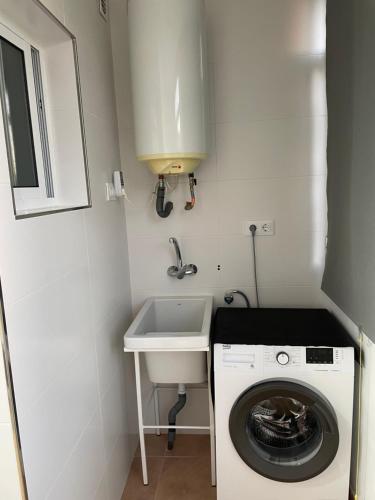 uma pequena casa de banho com uma máquina de lavar roupa e um lavatório em Apartamento CP em Cabo de Palos