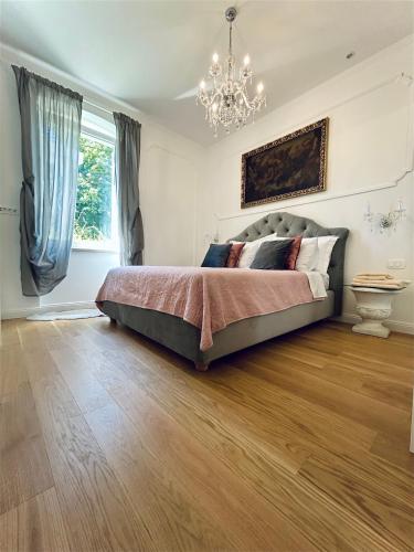 a bedroom with a bed and a chandelier at VILLA GIANNI - lux. apt. ROMA -5* in Lovran