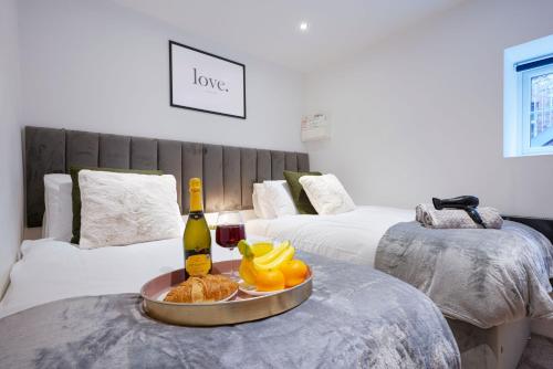 um quarto com duas camas e uma mesa com uma garrafa de vinho em Boutique Apartment - City Centre - Free Parking, Fast Wifi and Smart TV by Yoko Property em Rugby