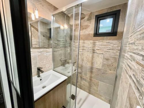 a bathroom with a sink and a glass shower at L'Essentiel - 50 m Plage de la Grande Conche in Saint-Georges-de-Didonne