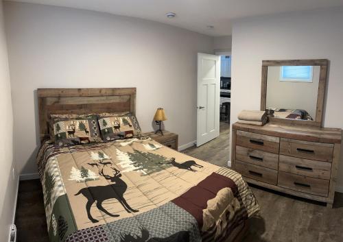 een slaapkamer met een bed, een dressoir en een spiegel bij One Bedroom basement suite in Carmacks