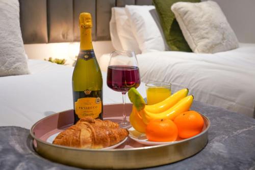 a tray of food and a bottle of wine and fruit at Boutique Apartment - City Centre - Free Parking, Fast Wifi and Smart TV by Yoko Property in Rugby