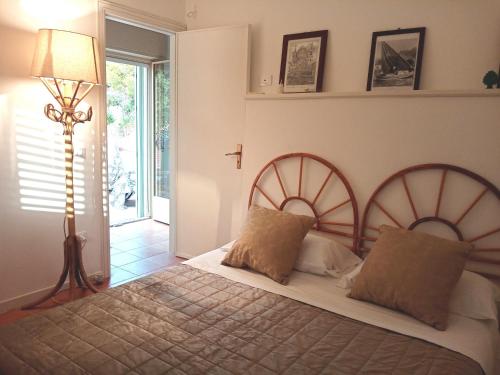 a bedroom with a bed with two pillows and a lamp at LE SORELLE entire villa sea view in Scopello