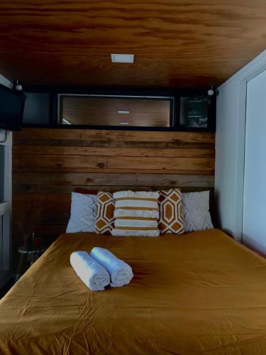 a bedroom with a bed with two towels on it at Onehunga Garden Tinyhouse in Auckland