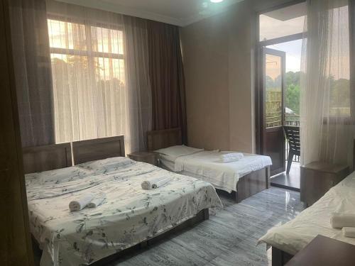 a hotel room with two beds and a balcony at HOTEL GUGA in Kobuleti