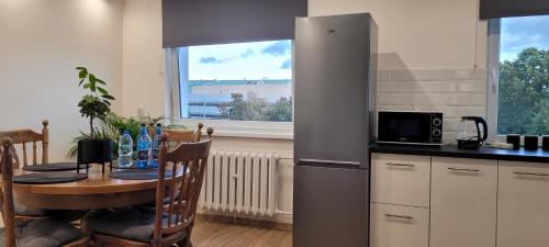 a kitchen with a table and a refrigerator at Incanto Apartament in Starogard Gdański