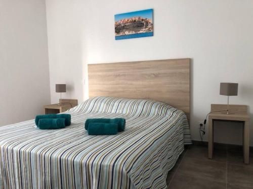 1 dormitorio con 1 cama con 2 almohadas verdes en Villa Noelly - Résidence les Hauts de Bonifacio, en Bonifacio