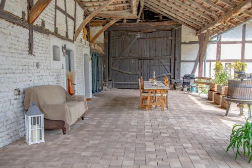 eine Terrasse mit einem Sofa und einem Tisch in einer Scheune in der Unterkunft Chambre indépendante n2 - Bretzel et Bergamote in Richtolsheim