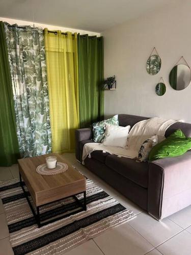 a living room with a couch and a coffee table at Appartement T2 très cosy in Cayenne