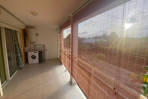 a room with a large sliding glass door with a window at Appartement T2 très cosy in Cayenne