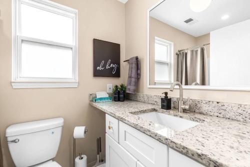 a bathroom with a sink and a toilet and a mirror at Spacious 1BR Upper Flat in the Heart of Roseville in Roseville